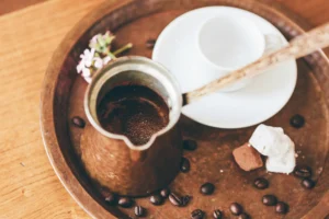 greek coffee in a coffee pot and a cup next to it
